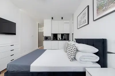 a bedroom with a bed with pillows and a tv at City center studio with a balcony - Rajska 3 in Kraków