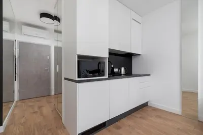 a kitchen with white cabinets and a tv on a counter at City center studio with a balcony - Rajska 3 in Kraków