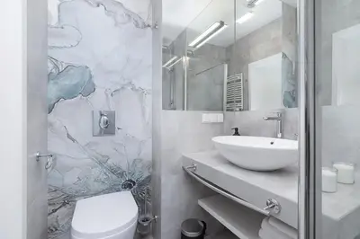 a bathroom with a white toilet and a sink at City center studio with a balcony - Rajska 3 in Kraków
