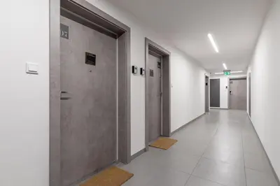 an empty hallway with doors and tile floors at City center studio with a balcony - Rajska 3 in Kraków