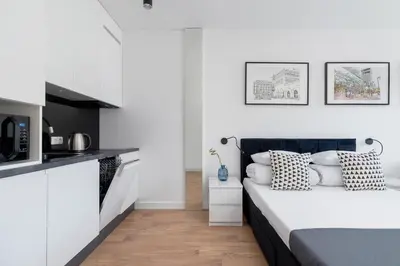 a bedroom with a bed and a kitchen at City center studio with a balcony - Rajska 3 in Kraków