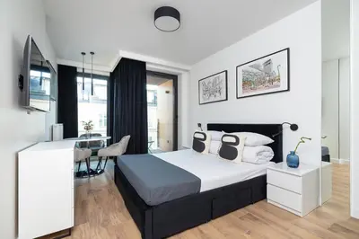 a bedroom with a large bed and a desk at Studio for two with a balcony - Rajska 3 street in Kraków