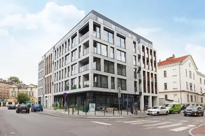 a large building on a city street with cars parked at Studio for two with a balcony - Rajska 3 street in Kraków