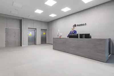 a man standing at a reception desk in an office at Studio for two with a balcony - Rajska 3 street in Kraków