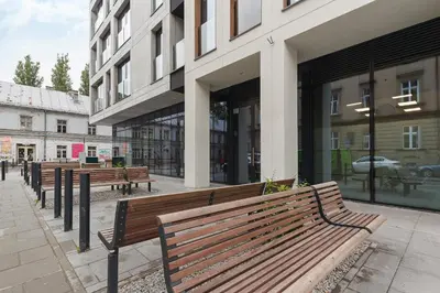 a row of benches in front of a building at Studio for two with a balcony - Rajska 3 street in Kraków