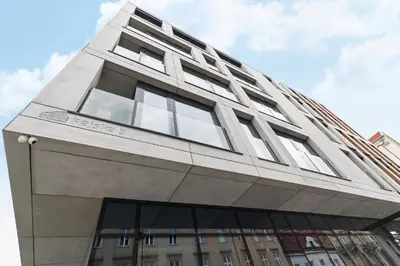 a tall white building with windows on top of it at Studio for two with a balcony - Rajska 3 street in Kraków