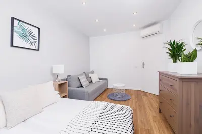 a white bedroom with a bed and a couch at Kazimierz District - Orzeszkowej 6 Street in Kraków