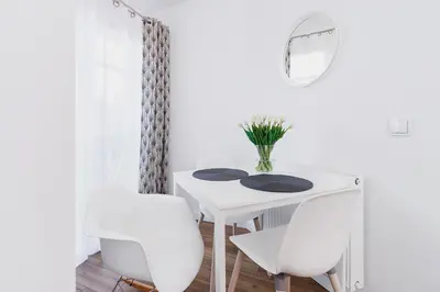 a white dining room table with two chairs and a mirror at Kazimierz District - Orzeszkowej 6 Street in Kraków
