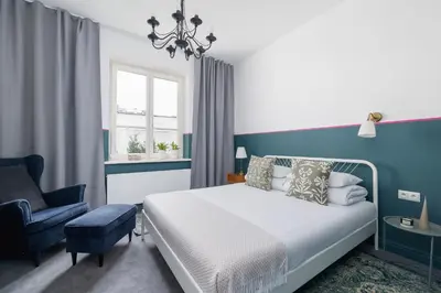 a blue and white bedroom with a bed and a chair at Św Jana Street - Main Square Apartment in Kraków