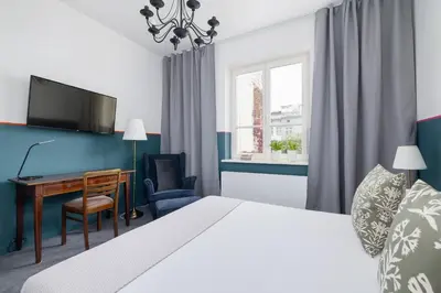 a bedroom with a bed and a desk with a computer at Św Jana Street - Main Square Apartment in Kraków