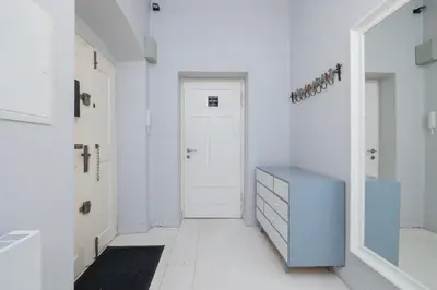 a hallway with a blue dresser and a door at Św Jana Street - Main Square Apartment in Kraków