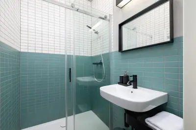 a bathroom with a sink and a glass shower at Św Jana Street - Main Square Apartment in Kraków