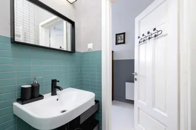 a bathroom with a sink and a mirror at Św Jana Street - Main Square Apartment in Kraków