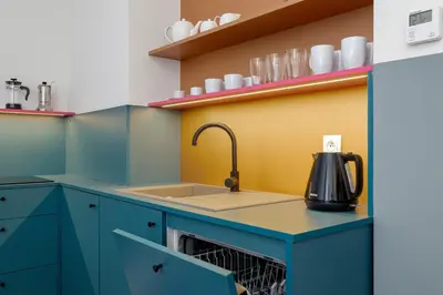 a kitchen with blue cabinets and a sink at Św Jana Street - Main Square Apartment in Kraków