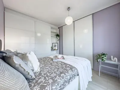 a bedroom with a bed with a gray and white blanket at Nadwiślańska Przystań Apartament z widokiem na Wisłę in Kraków