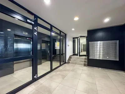 a hallway with glass doors and stairs in a building at Nadwiślańska Przystań Apartament z widokiem na Wisłę in Kraków
