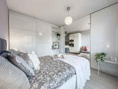 a bedroom with a large bed with white walls at Nadwiślańska Przystań Apartament z widokiem na Wisłę in Kraków
