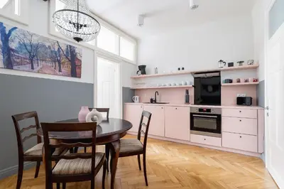 a dining room with a table and chairs and a kitchen at 2 bedroom apartment Św Jana - Main Square in Kraków