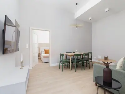 a dining room and living room with a table and chairs at 4 Bedroom Apartment - Main Square in Kraków