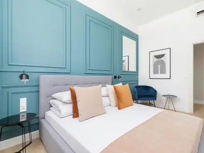 a blue bedroom with a bed with orange and white pillows at 4 Bedroom Apartment - Main Square in Kraków