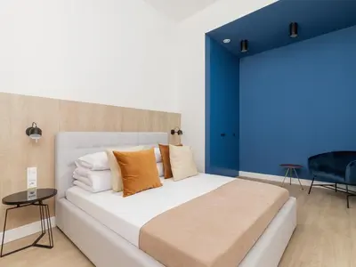 a bedroom with a large bed with a blue wall at 4 Bedroom Apartment - Main Square in Kraków