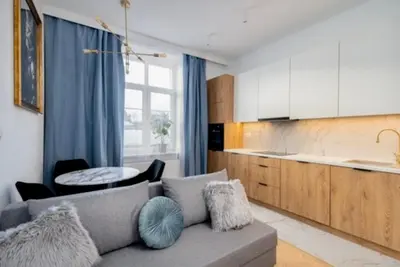 a living room with a couch and a kitchen at Dębowa 4 by Homeprime in Kraków