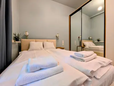 a bedroom with a large white bed with towels on it at Dębowa 4 by Homeprime in Kraków