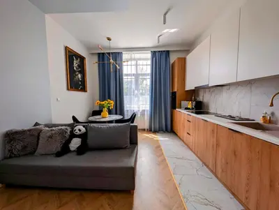a living room with a couch and a kitchen at Dębowa 4 by Homeprime in Kraków