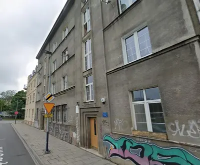 a building with graffiti on the side of it on a street at Dębowa 4 by Homeprime in Kraków