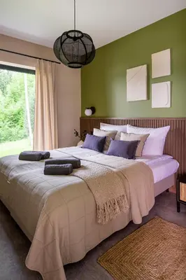a large bed in a bedroom with green walls at Przystań Brzozowa Polana - Jezioro Mucharskie in Dąbrówka