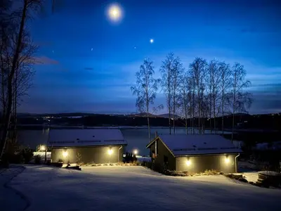 a house in the snow at night with the moon at Przystań Brzozowa Polana - Jezioro Mucharskie in Dąbrówka