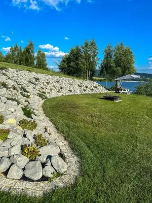 a rock garden with flowers on a grass field at Przystań Brzozowa Polana - Jezioro Mucharskie in Dąbrówka