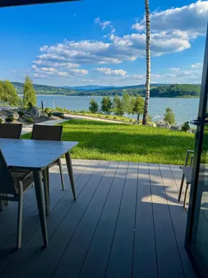 a deck with a table and chairs and a view of the water at Przystań Brzozowa Polana - Jezioro Mucharskie in Dąbrówka