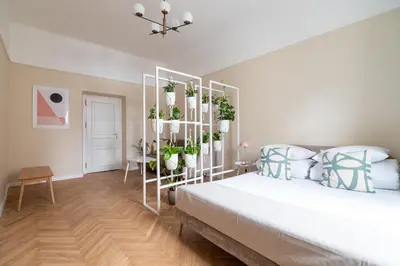a bedroom with a bed with plants on a shelf at 2 - bedroom apartment - Rejtana 10 in Kraków