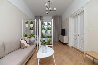 a living room with a couch and a table with plants at 2 - bedroom apartment - Rejtana 10 in Kraków