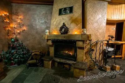 a living room with a fireplace and a christmas tree at Prawdziwy domek w górach in Nowy Targ