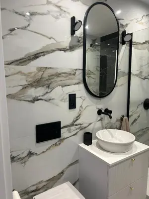 a bathroom with a sink and a mirror on a wall at Vintage Kalwaryjska Apartment in Kraków