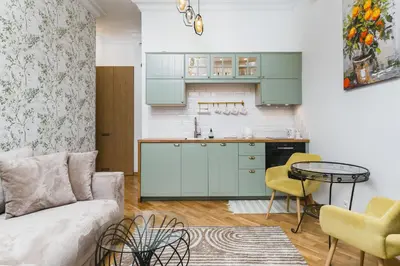 a living room with a couch and a kitchen at Vintage Kalwaryjska Apartment in Kraków