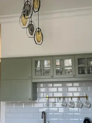 a kitchen with green cabinets and a sink at Vintage Kalwaryjska Apartment in Kraków
