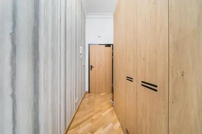 a hallway with wooden lockers and a door at Vintage Kalwaryjska Apartment in Kraków