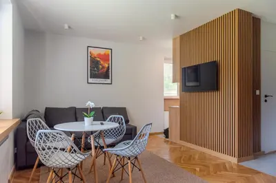 a living room with a table and chairs and a couch at Apartament Słoneczny Rabka Zdrój in Rabka-Zdroj