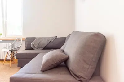 a gray couch with pillows in a living room at Apartament Słoneczny Rabka Zdrój in Rabka-Zdroj