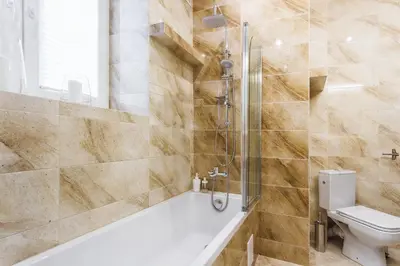 a bathroom with a tub and a toilet at Two Bedroom Apartment - Rzeszowska 8 Street in Kraków