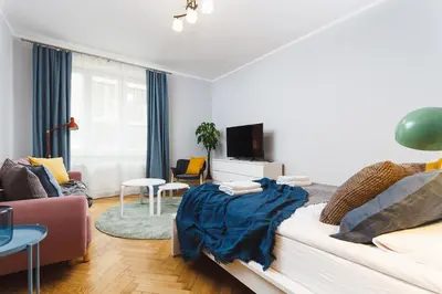 a bedroom with a bed and a living room at Two Bedroom Apartment - Rzeszowska 8 Street in Kraków