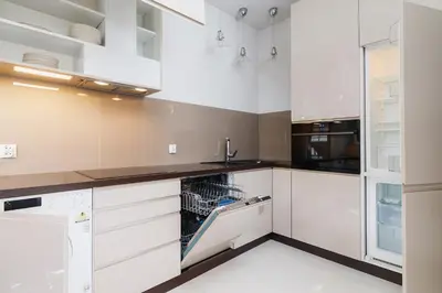a kitchen with white cabinets and a dishwasher at Apartment with Private Parking - Lubicz 17 street in Kraków