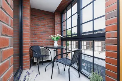 a balcony with a table and chairs and windows at Apartment with Private Parking - Lubicz 17 street in Kraków