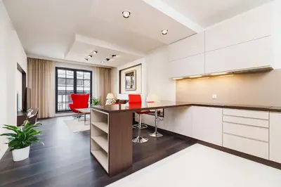 an apartment kitchen with a desk and red chairs at Apartment with Private Parking - Lubicz 17 street in Kraków