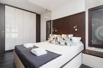 a bedroom with a large white bed with a table at Apartment with Private Parking - Lubicz 17 street in Kraków