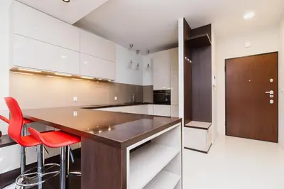 a kitchen with a wooden counter and red chairs at Apartment with Private Parking - Lubicz 17 street in Kraków