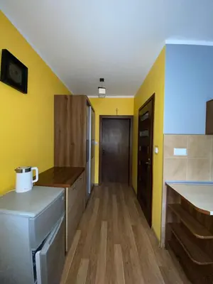 a kitchen with yellow walls and a wooden floor at Jelonek Zawoja in Zawoja
